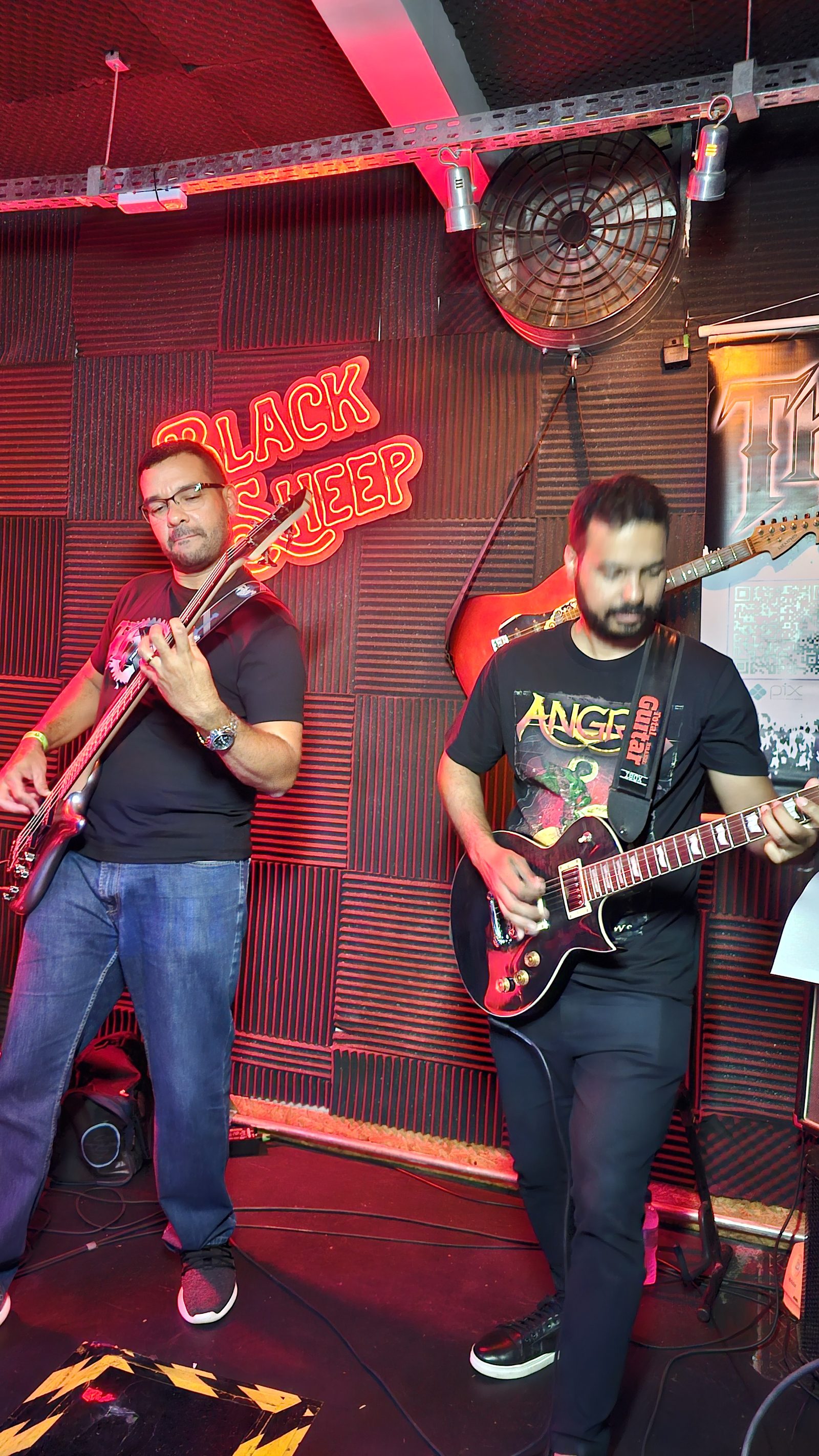 Baixo e guitarra da Thork no Black Sheep — neon ao fundo