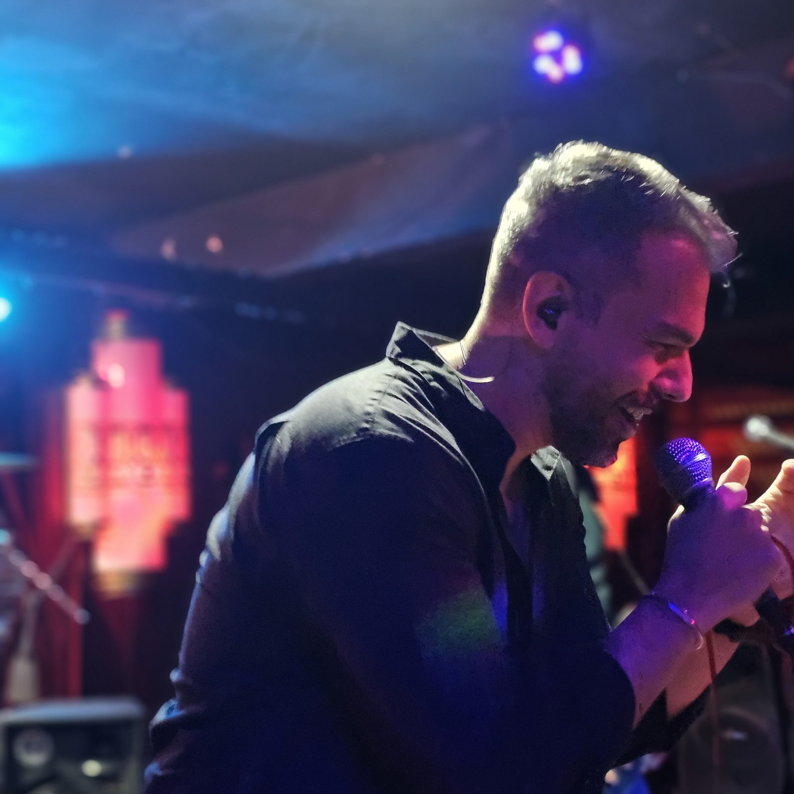 Vocalista da Thork em close — luzes azul e magenta